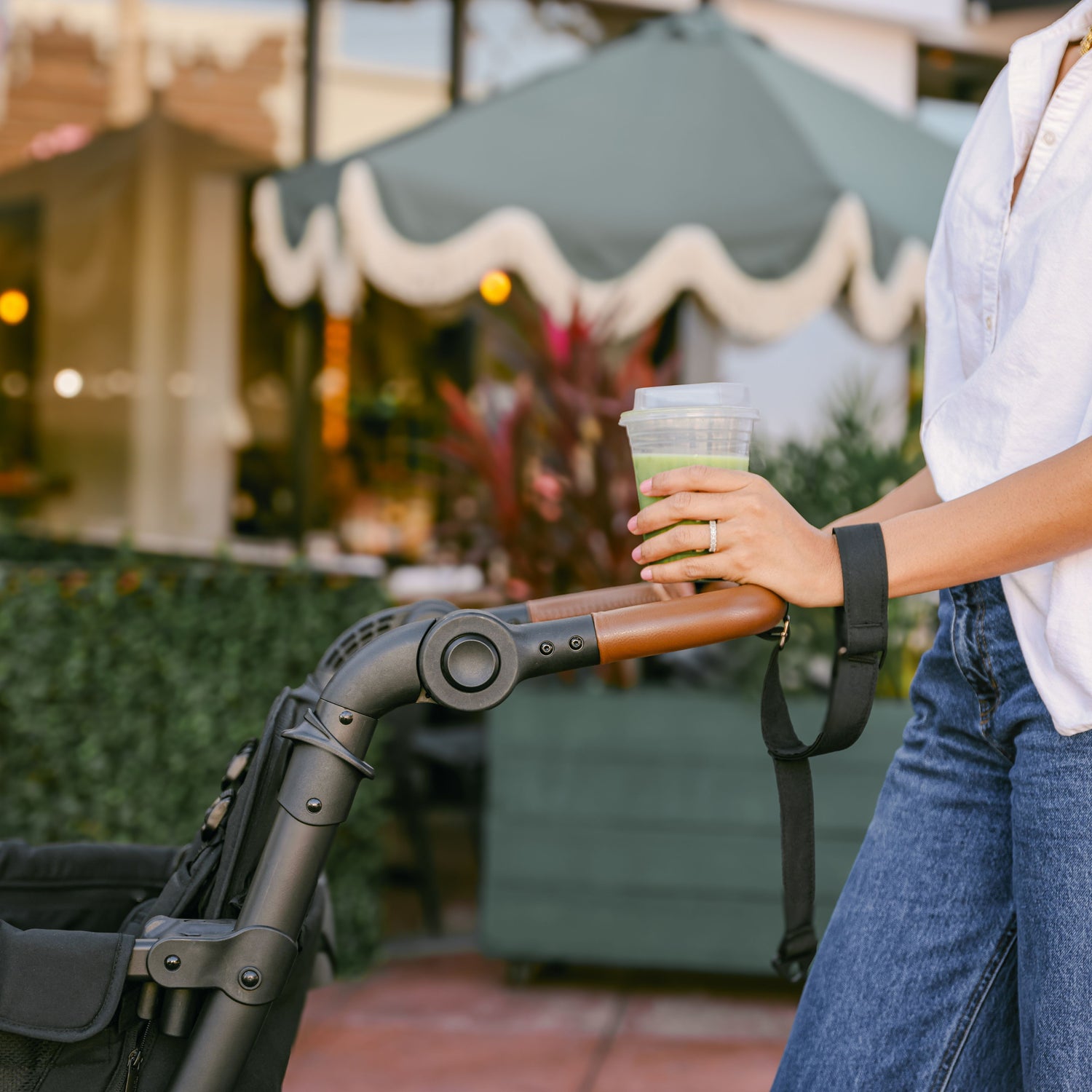 A woman adjusting the handlebar of the WonderFold L4 stroller wagon, highlighting its ergonomic design.
